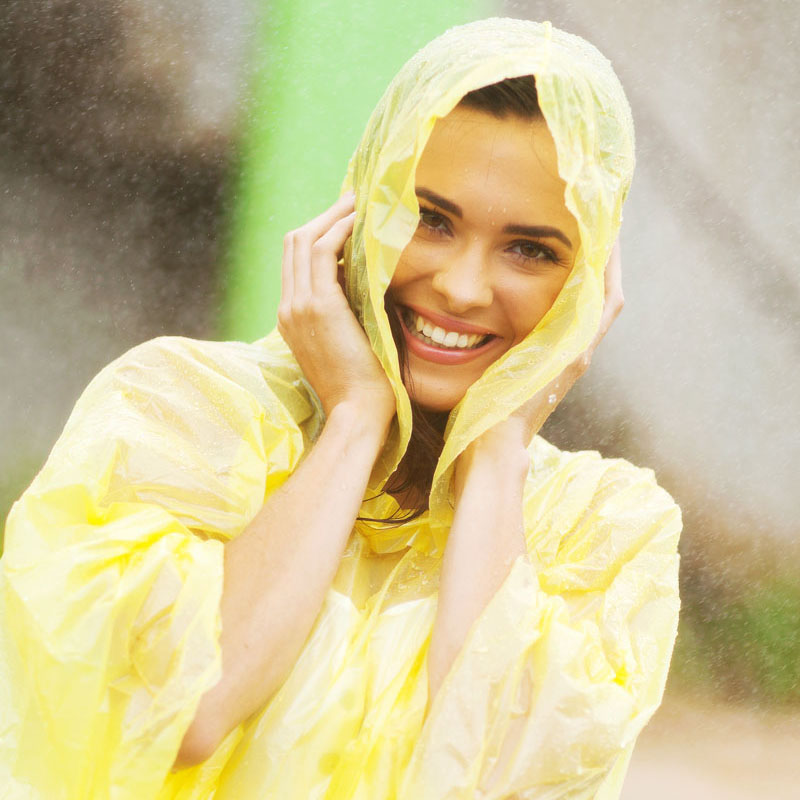 really happy woman wearing yellow poncho in the rain