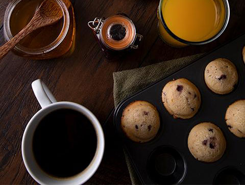 blueberry muffins with coffee, orange juice, and syrup